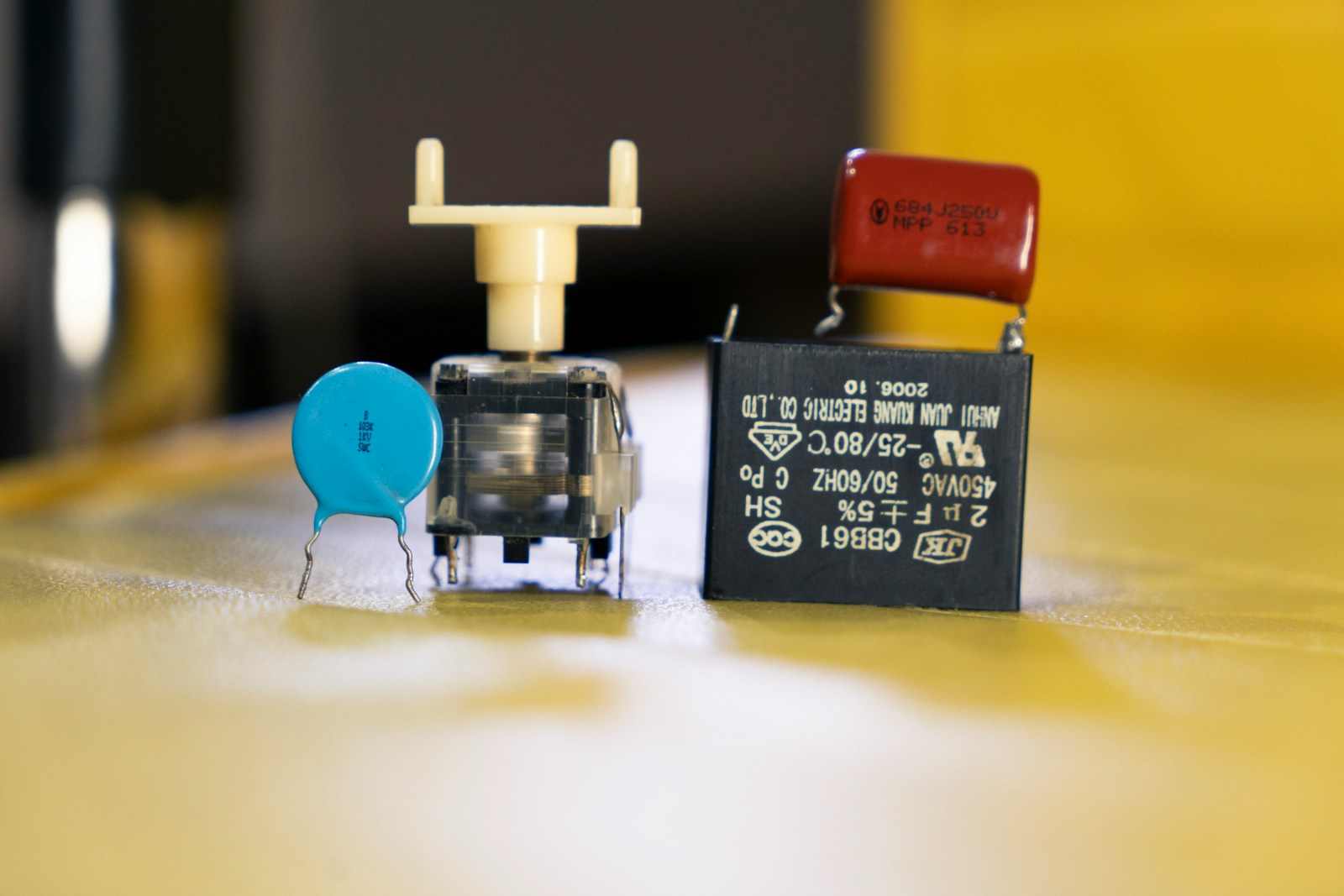 Two small electronic components on a wooden surface.